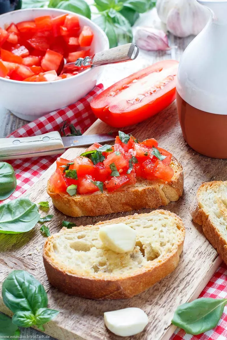 Nahaufnahme von gewürfelten Tomaten auf einem Holzbrett, bereit für Bruschetta