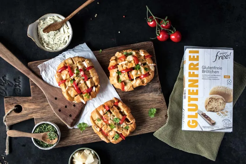 Nahaufnahme von glutenfreien Aufbackbrötchen, bereit zum Backen, mit der Saaten-Sorte im Vordergrund