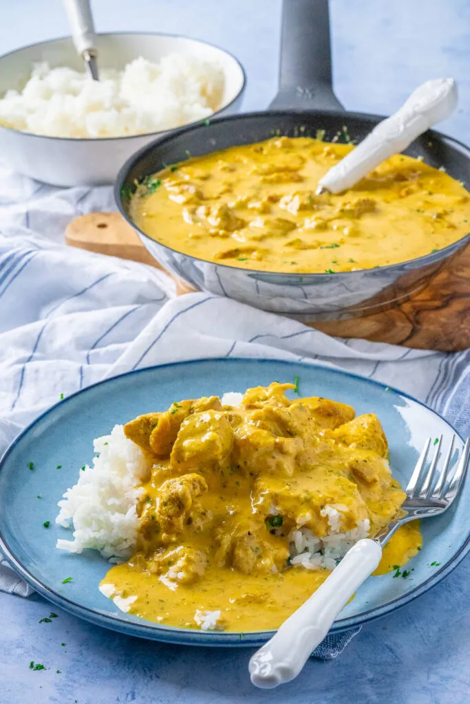 Nahaufnahme von Hähnchen-Curry-Geschnetzeltem mit Reis, die cremige Soße ist deutlich sichtbar