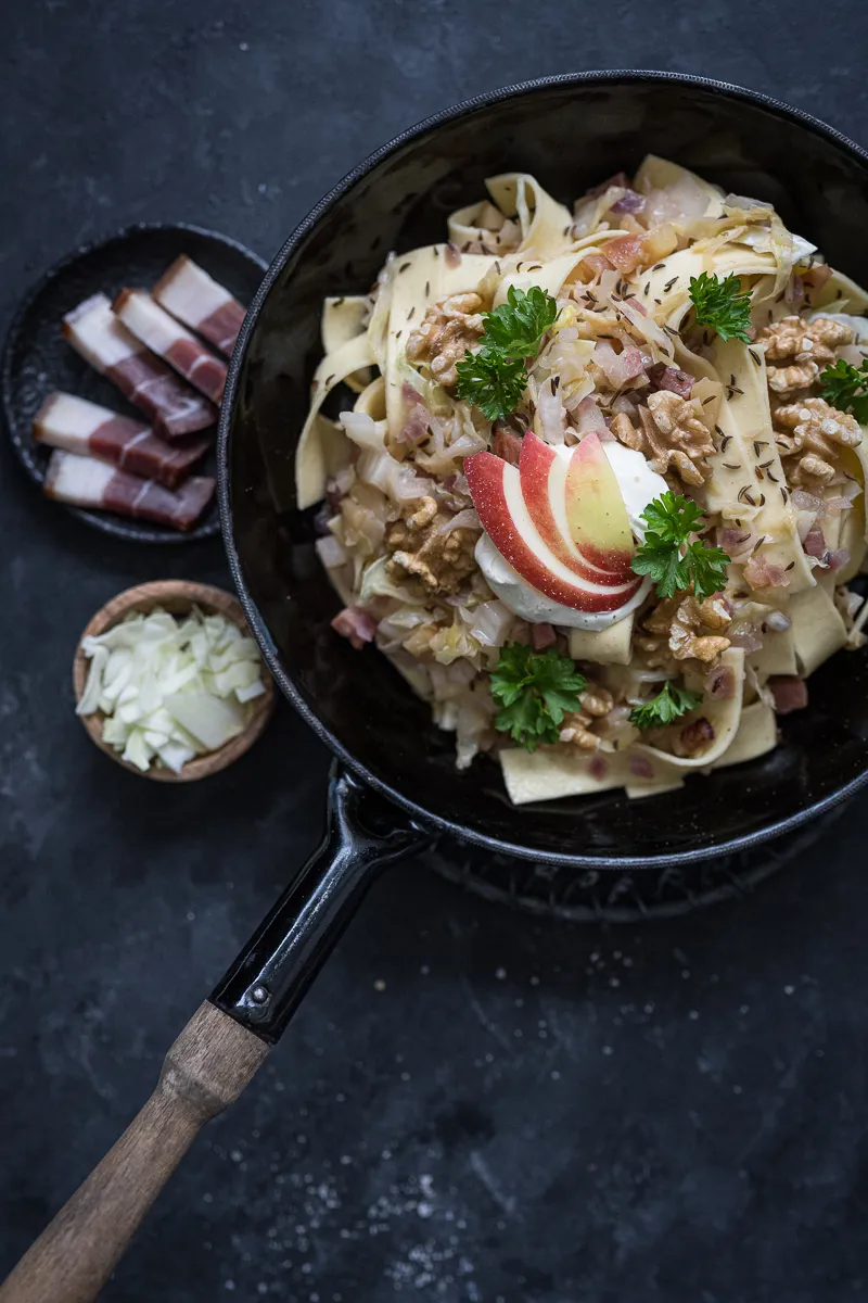 Nahaufnahme von Krautfleckerl mit Spitzkohl, Speck und Walnüssen