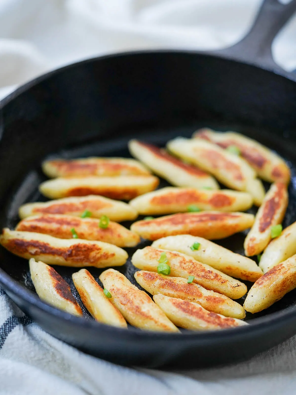 Nahaufnahme von kross gebratenen Schupfnudeln in der Pfanne