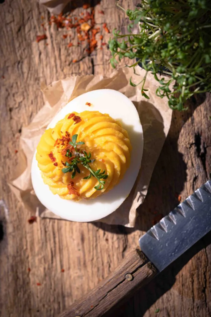 Nahaufnahme von kunstvoll gefüllten russischen Eiern, garniert mit frischen Kräutern