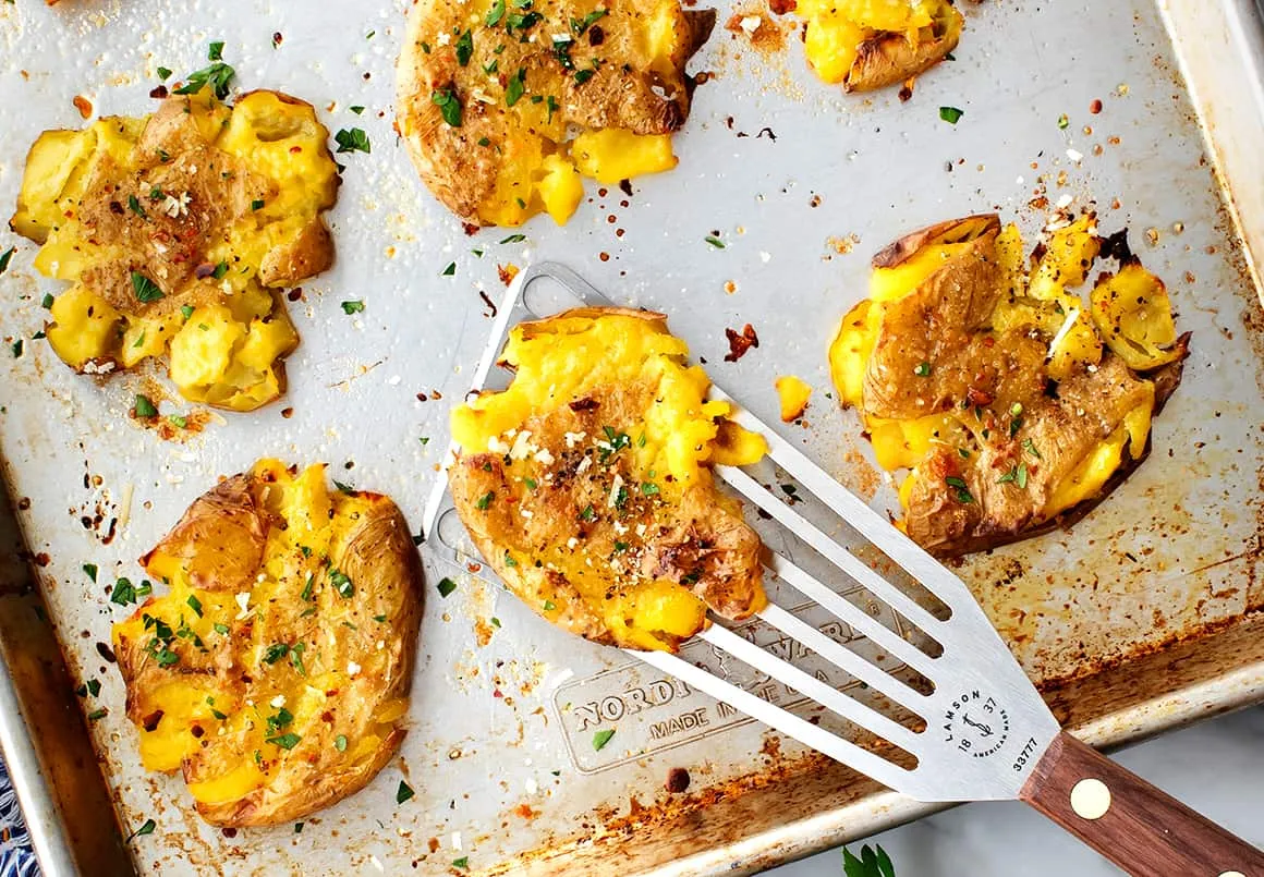 Nahaufnahme von perfekt gebackenen, goldbraunen Smashed Potatoes als Beilage