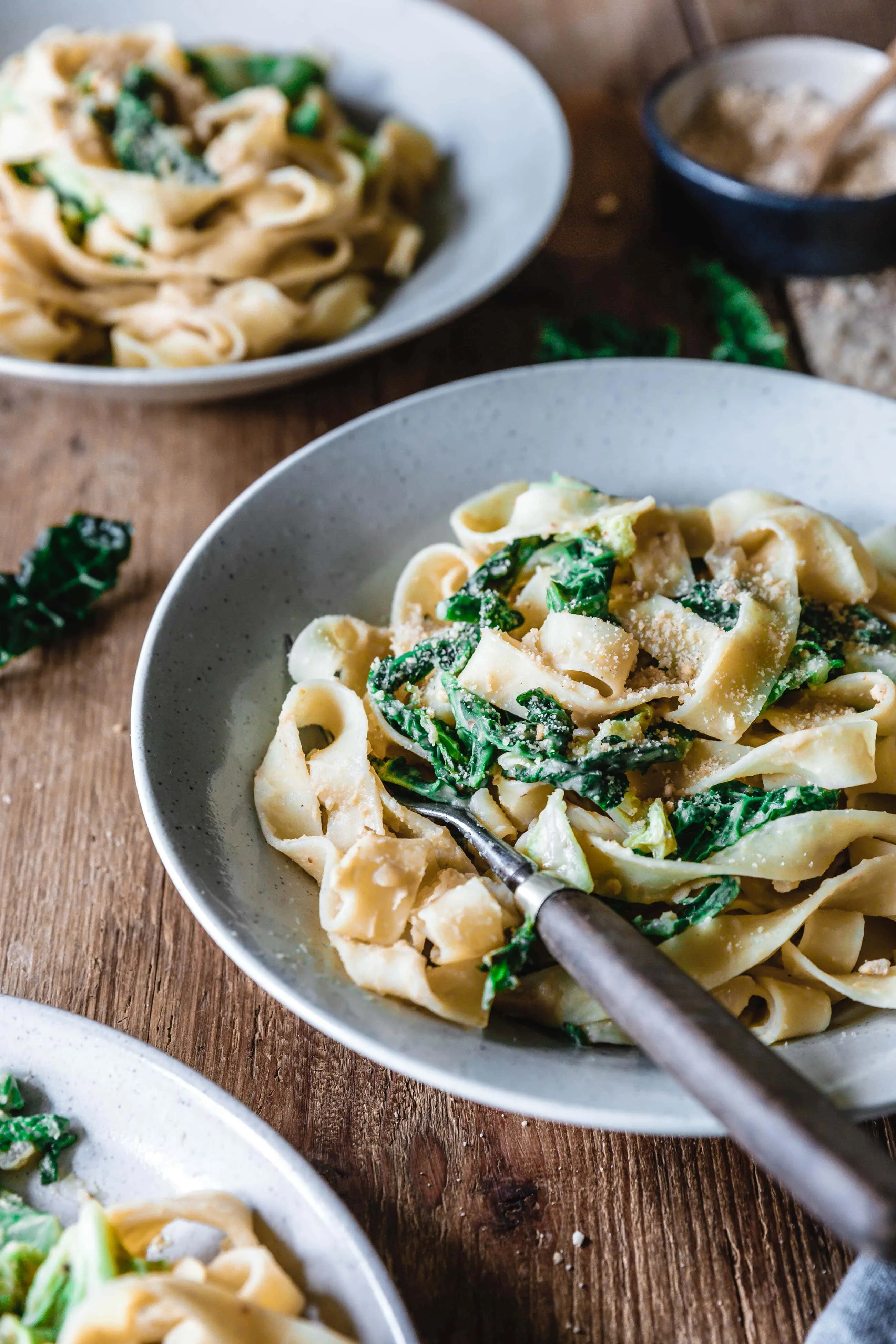 Nahaufnahme von veganen Wirsing-Tagliatelle mit Kichererbsen-Hummussauce in einer Pfanne, die die Textur und cremige Konsistenz zeigt