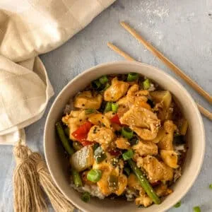 Nahaufnahme von zarten Hähnchenstücken in würziger chinesischer Sauce.