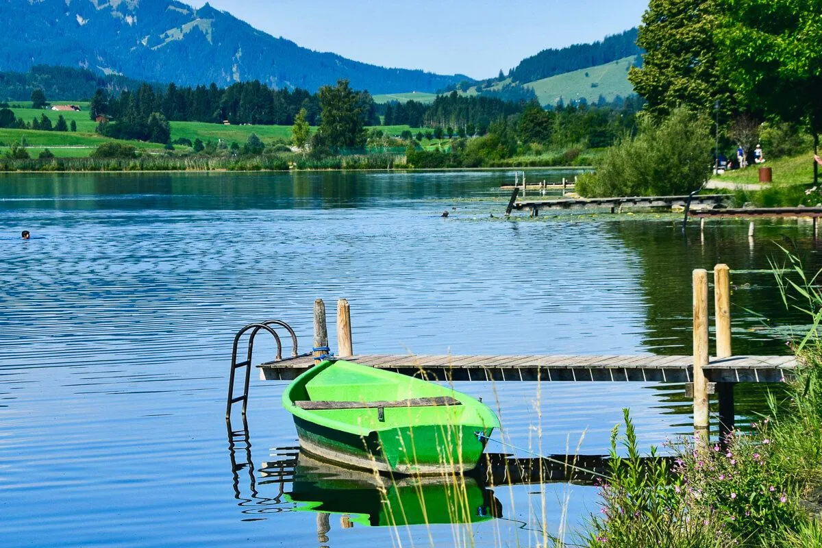 Naturparadies: Ein Ruderboot auf dem Hopfensee bei Füssen, umgeben von alpiner Landschaft