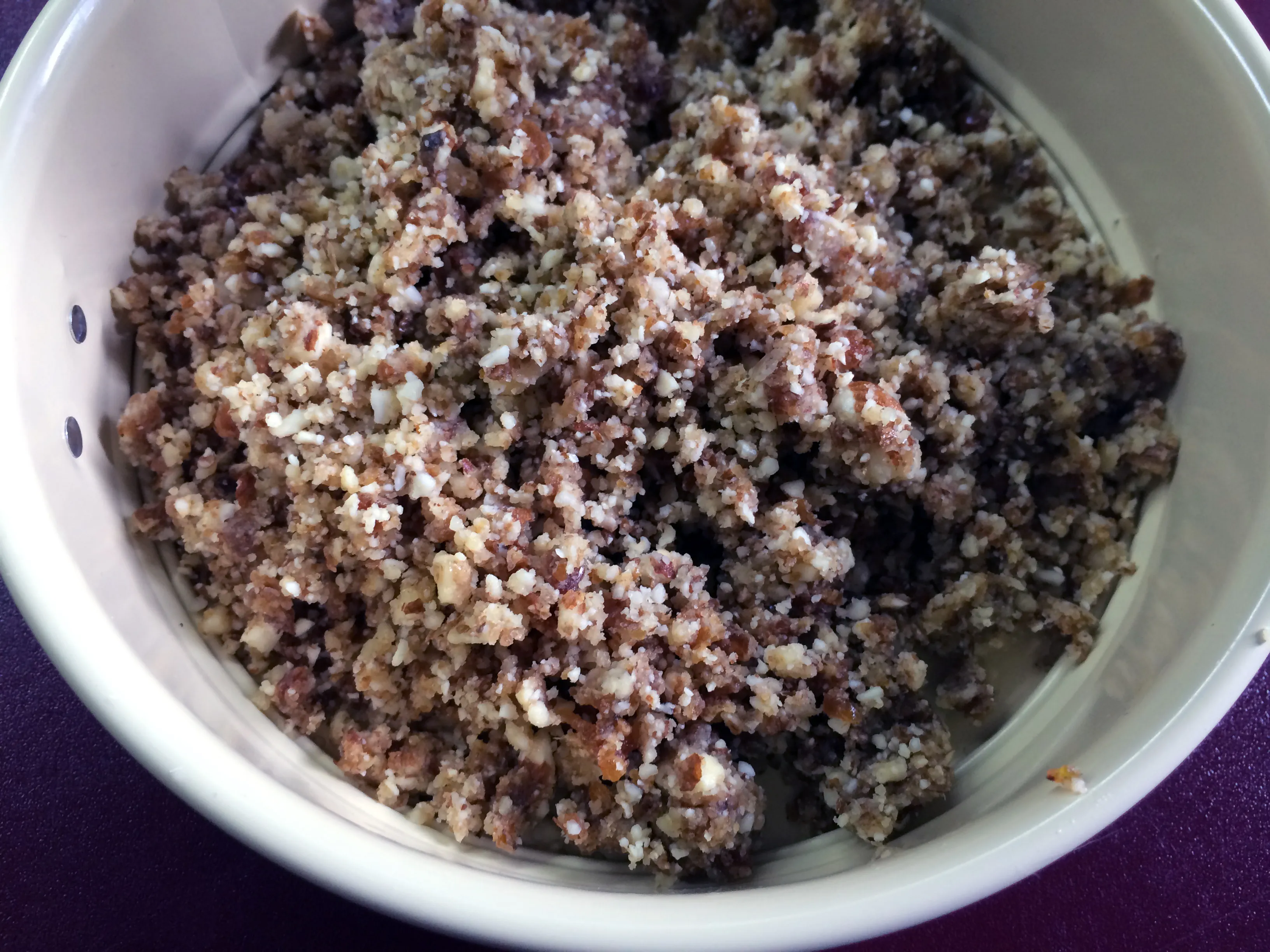 Nuss-Dattel-Masse wird in die Springform gedrückt, als Boden für den zuckerfreien Kuchen