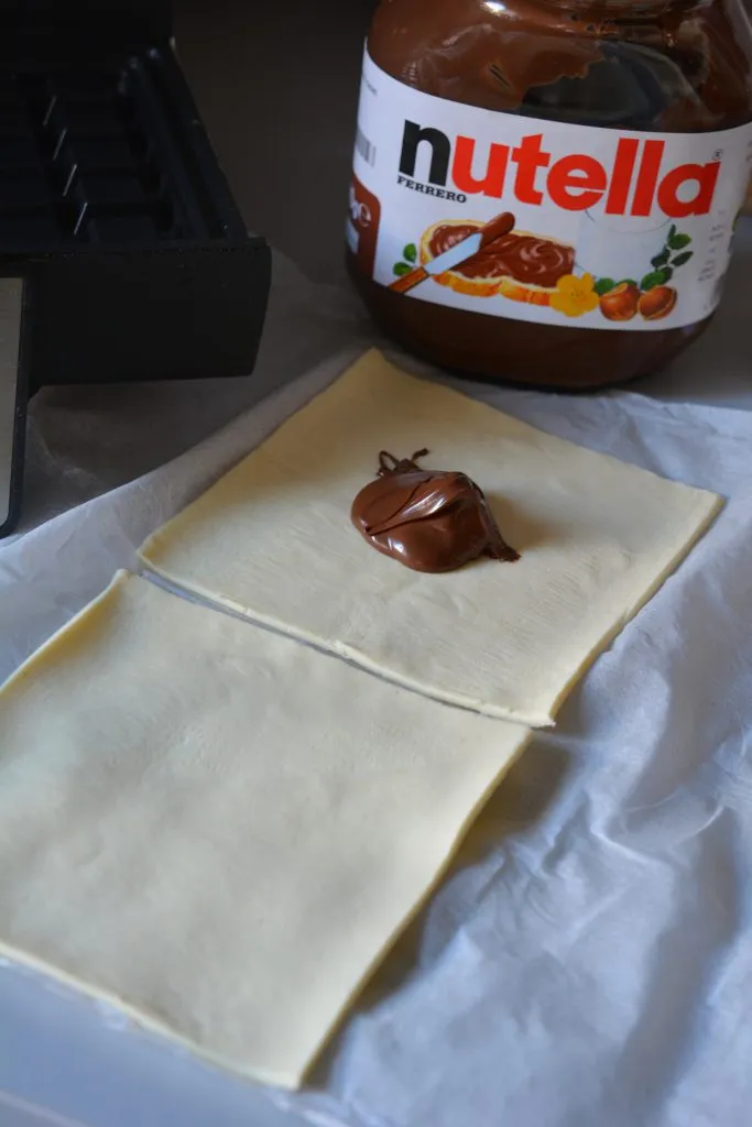 Nuss-Nougat-Creme auf Blätterteig-Quadrate streichen