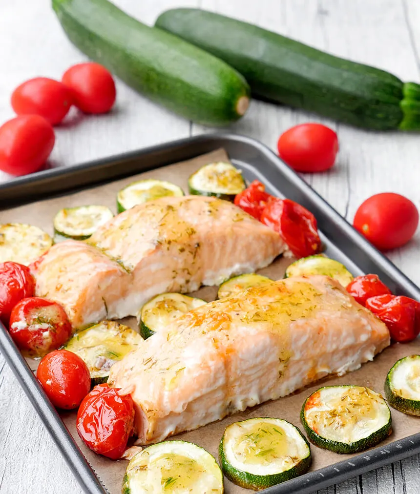 Ofenlachs mit Tomaten und Zucchini auf dem Backblech