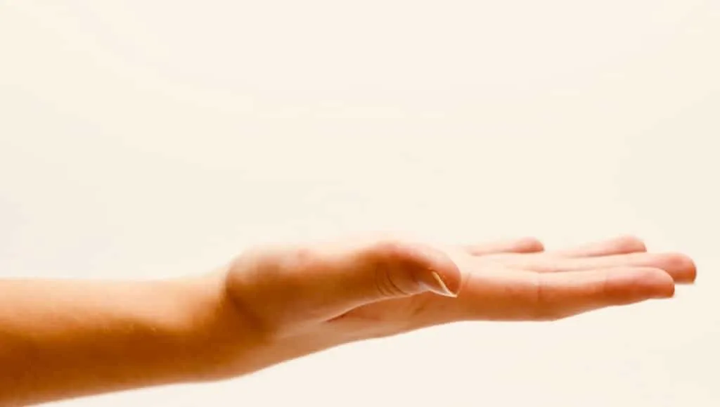 Offene Hand vor warmem, weißem Hintergrund symbolisiert Pflege mit Apfelessig in der Kosmetik