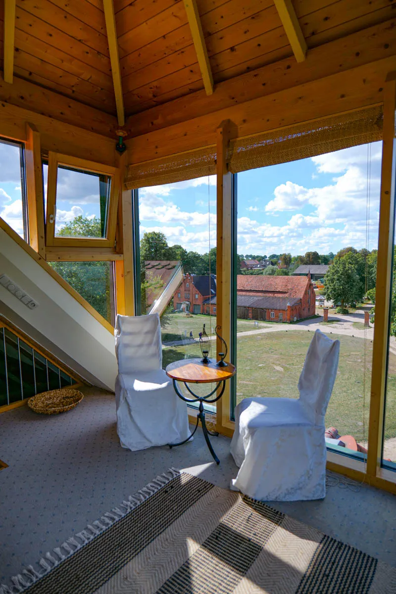 Offener Wohnbereich im Turmzimmer mit rustikalen Holzbalken