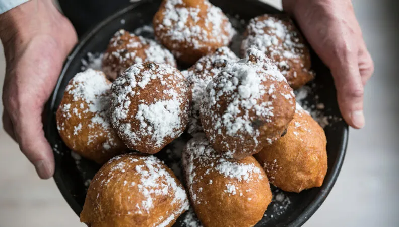 Oliebollen mit Puderzucker bestreut, ein traditioneller Silvester-Snack in den Niederlanden