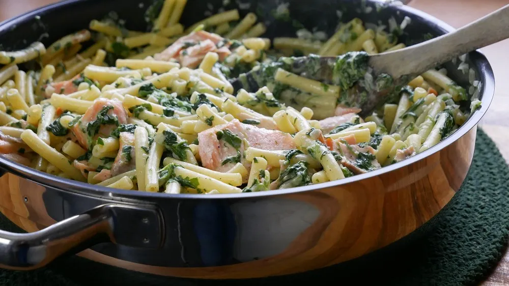 One Pot Pasta mit geräuchertem Lachs und frischem Spinat, servierfertig angerichtet.