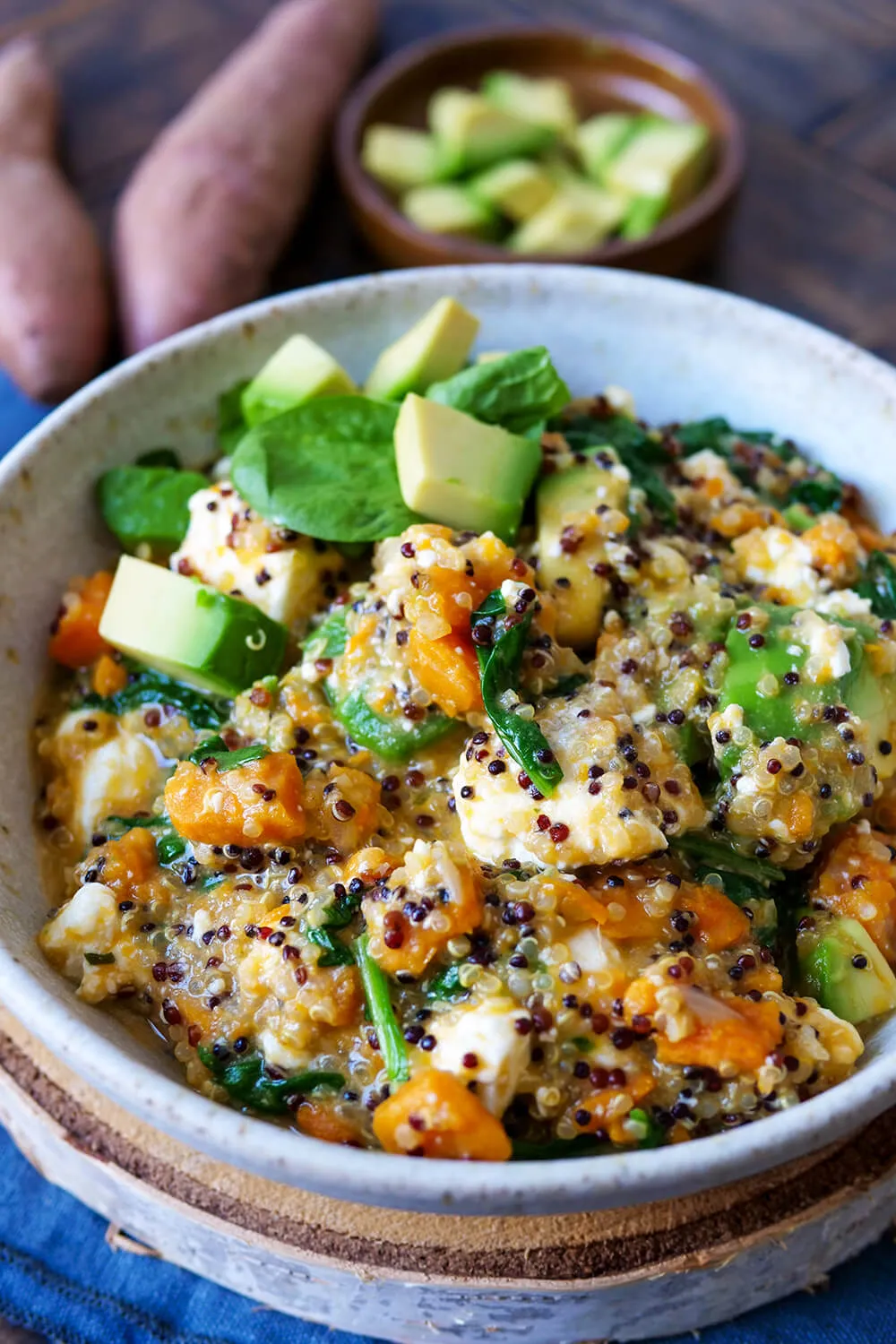 One Pot Quinoa mit Süßkartoffeln, Avocado, Spinat und Feta in der Schüssel. Alternative Text: Farbenfrohe Quinoa Bowl mit Süßkartoffeln, Avocado, Spinat und Feta, ein gesundes und schnelles Mittagessen, reich an Vitaminen und Mineralstoffen.