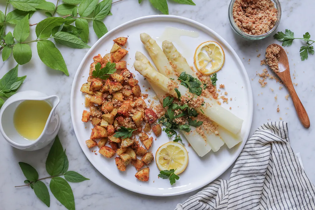 Optimal gelagerter weißer Spargel und knusprige Röstkartoffeln, ein Symbol für frische deutsche Küche.