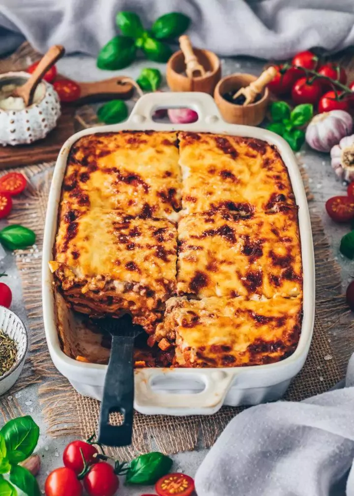 Original italienische Lasagne mit veganer Bolognese aus Hackfleischalternative und cremiger Béchamelsauce, appetitlich angerichtet.