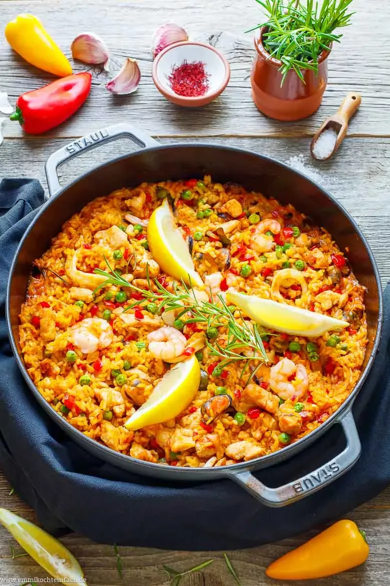 Paella in der Pfanne mit Hähnchen und Meeresfrüchten, goldgelb und appetitlich