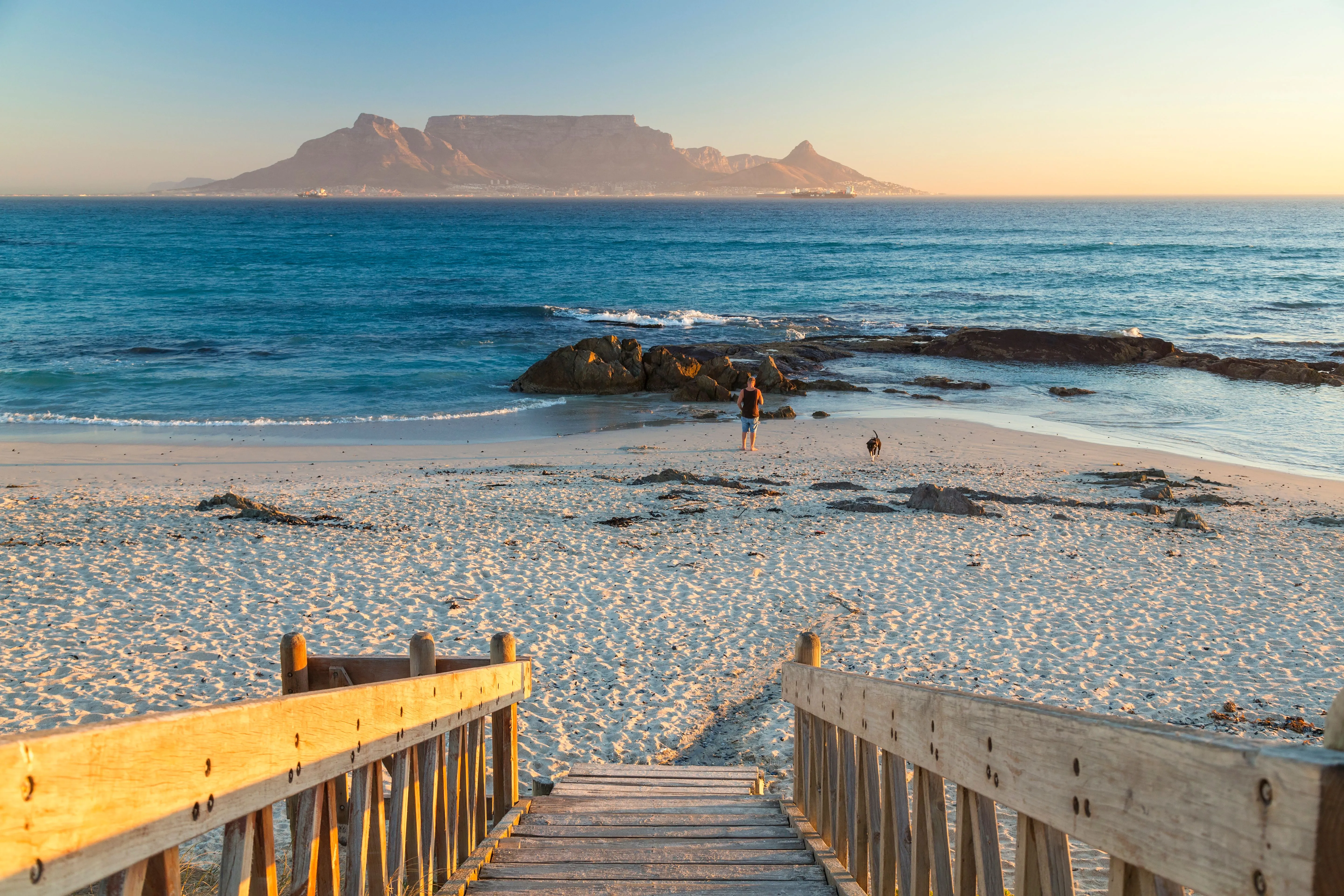 Panoramablick auf den Strand von Kapstadt mit dem Tafelberg im Hintergrund, perfektes Reiseziel für sonnige Reisen im Februar warm.