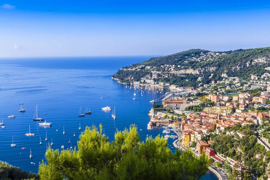 Panoramablick auf die französische Riviera bei Nizza mit azurblauem Meer und Küstenstädten, ideal für sommerliche Ferien im Juli.