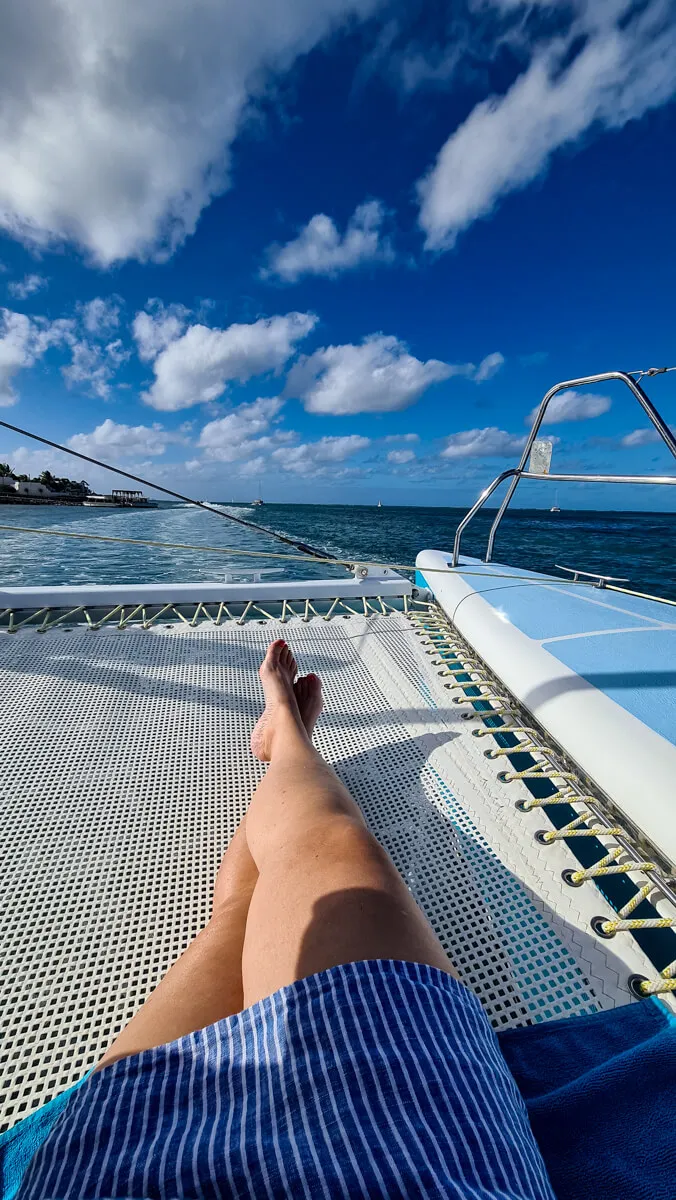 Passagier genießt die Sonne an Bord eines Katamarans auf Mauritius, perfekt für eine Fernreise im Sommer