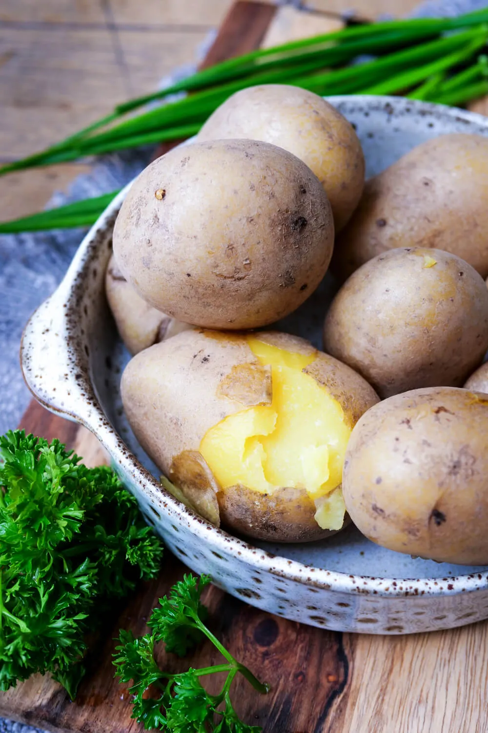 Pellkartoffeln auf einem Teller, eine Kartoffel ist aufgeplatzt.