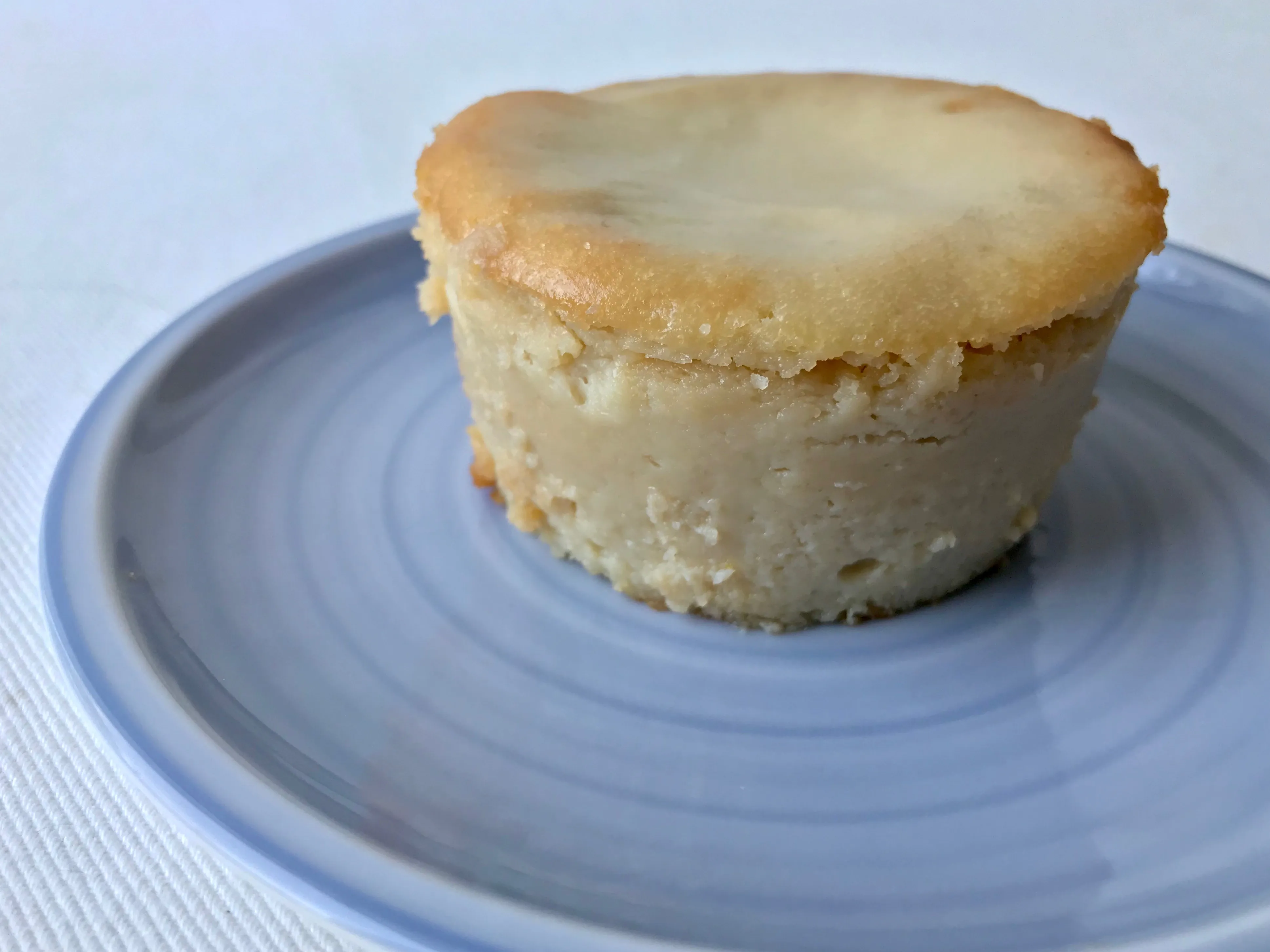 Perfekt cremiger, hellgelber veganer Käsekuchen mit glänzender Oberfläche in einer kleinen Auflaufform