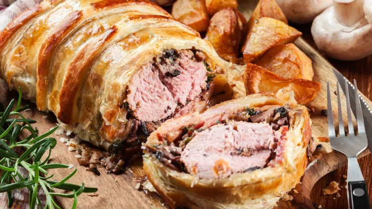 Perfekt gebackenes Schweinefilet im Blätterteig, goldbraun und appetitlich angerichtet.