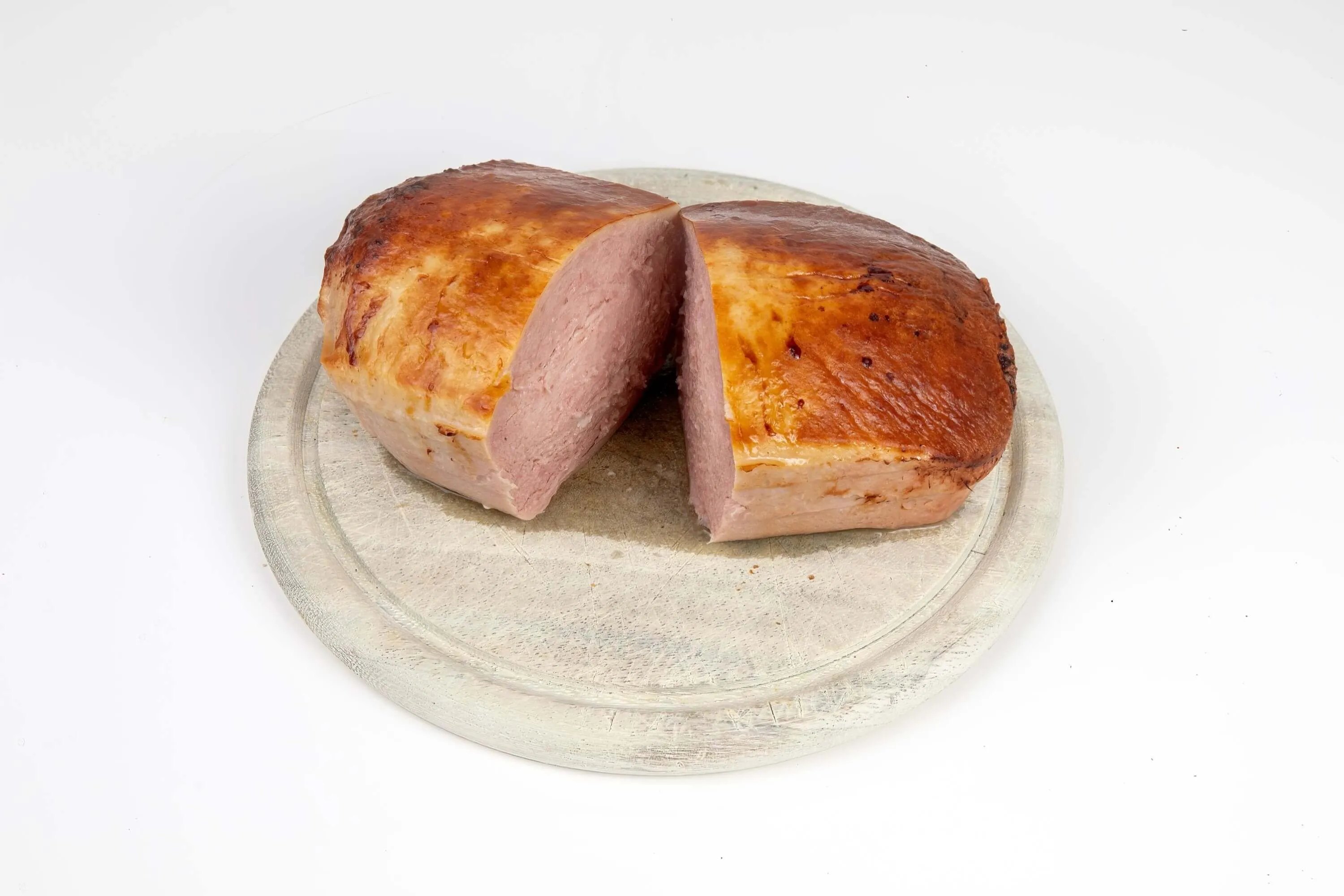 Perfekt gegarter bayerischer Leberkäse, saftig aufgeschnitten und servierfertig auf einem Holzbrett. Ideal für Kenner der Kerntemperatur Leberkäse.