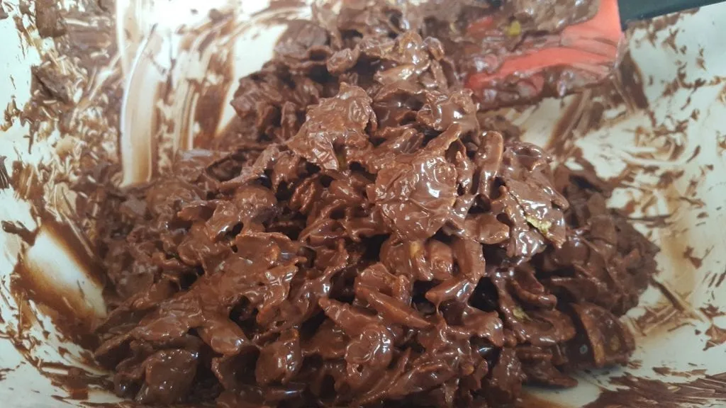 Perfekt ummantelte Cornflakes und Mandeln in der Schokomasse, die Basis für Schoko Crossies.
