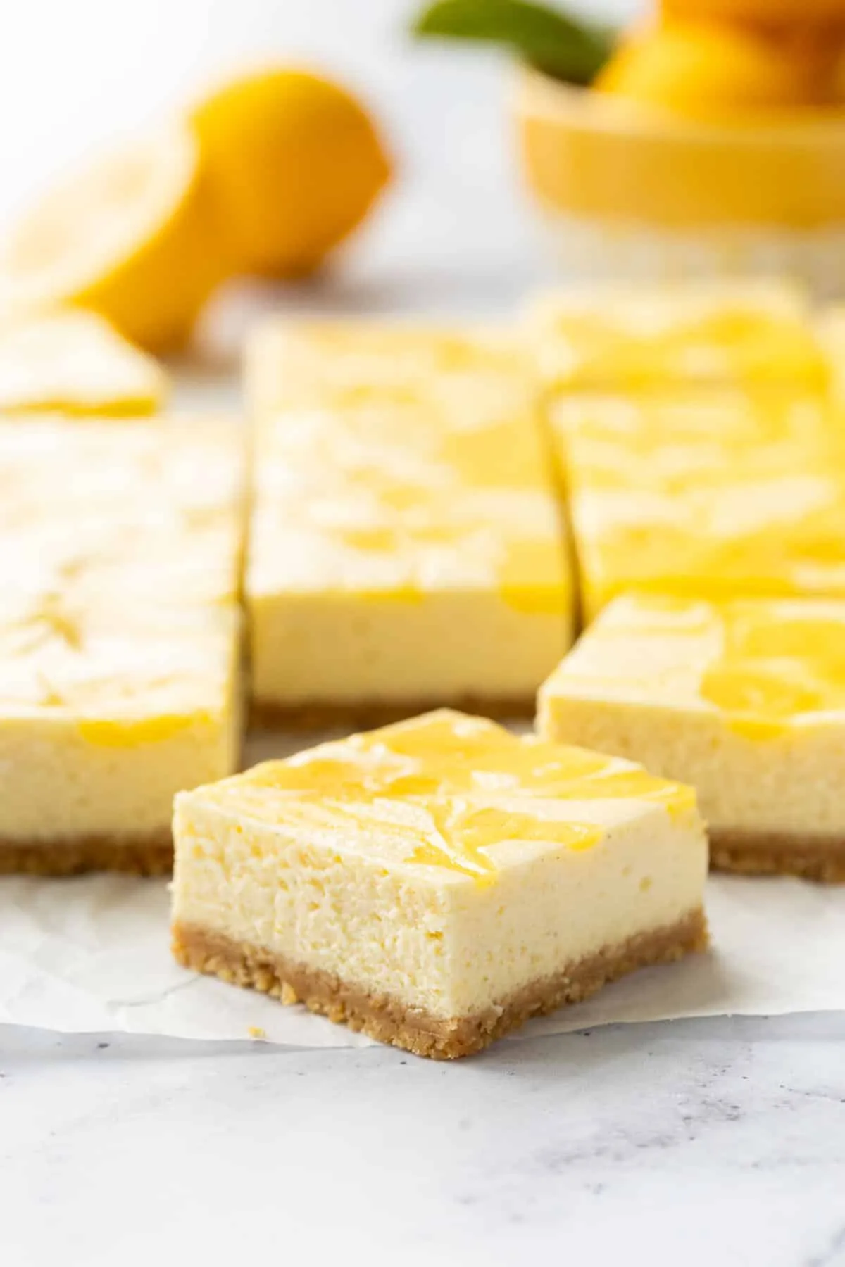 Perfekter Schnitt eines Zitronen-Käsekuchenriegels mit sichtbaren Schichten von Keksboden, Käsekuchen und Lemon Curd.
