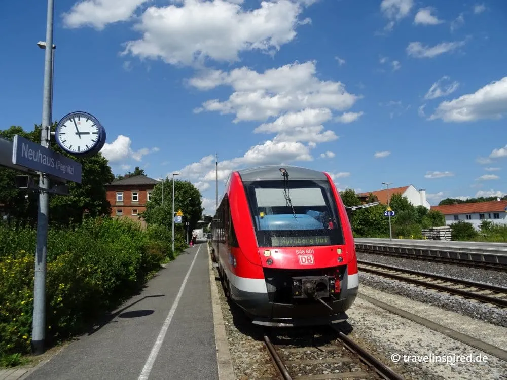 Person mit Rucksack und Wanderstöcken neben einem Bahnsteig, Neuhaus an der Pegnitz