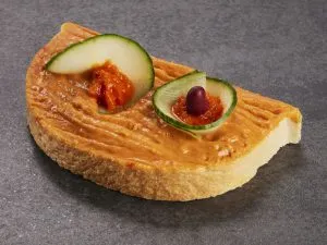 Pikanter Hummus-Aufstrich mit Kräutern auf einem Brötchen