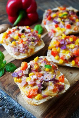 Pizzabrötchen mit Mais, Paprika und Pilzen belegt und überbacken, ein herzhafter Snack