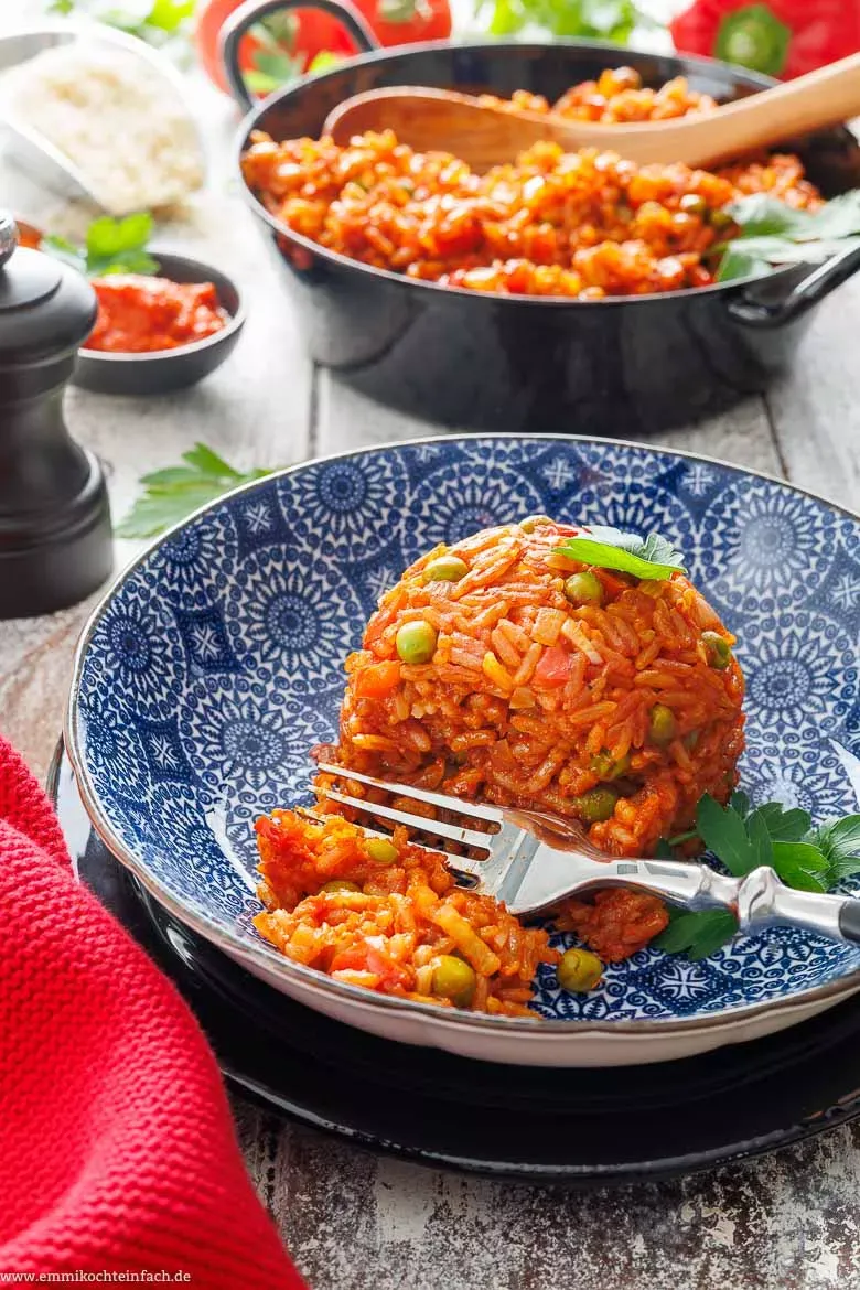 Portion Djuvec Reis mit frischen Kräutern in einem tiefen Teller, als vollständige Mahlzeit