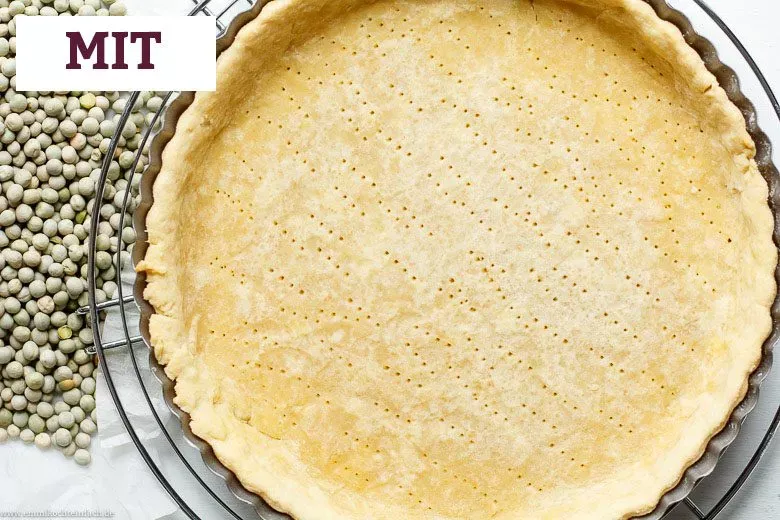 Quiche Teig perfekt blindgebacken mit getrockneten Hülsenfrüchten für stabilen Rand.
