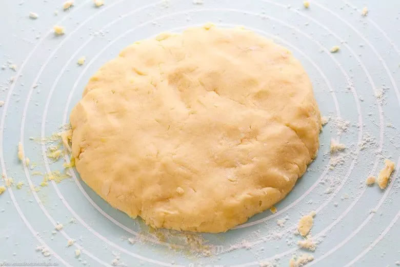 Quiche Teig zu einer flachen Scheibe geformt, bereit zur Kühlung.