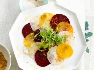 Raffiniertes Rüben-Carpaccio, eine dünn geschnittene basische Mahlzeit, die leicht und farbenfroh ist.