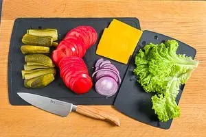 Restlichen Zutaten für das Belegen des Burgers vorbereiten: Frisches Gemüse und saure Gurken sorgen für den perfekten Burger-Belag.