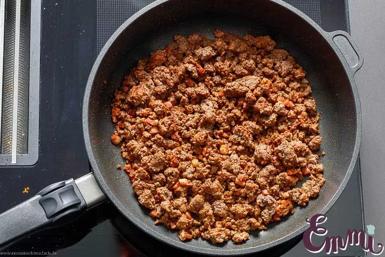 Rinderhackfleisch und Speckwürfel werden in der Pfanne für die Auflaufsoße angebraten