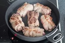 Rinderrouladen werden in Butterschmalz scharf angebraten, um eine goldbraune Kruste und intensive Röstaromen zu entwickeln.
