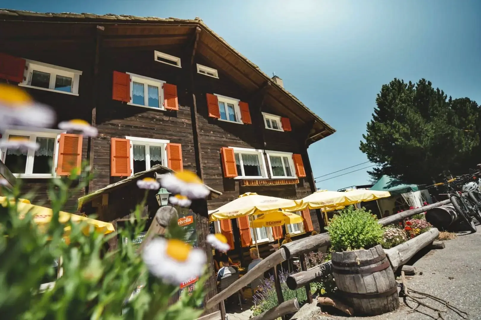 Rivella vor einem traditionellen Restaurant in den Schweizer Alpen