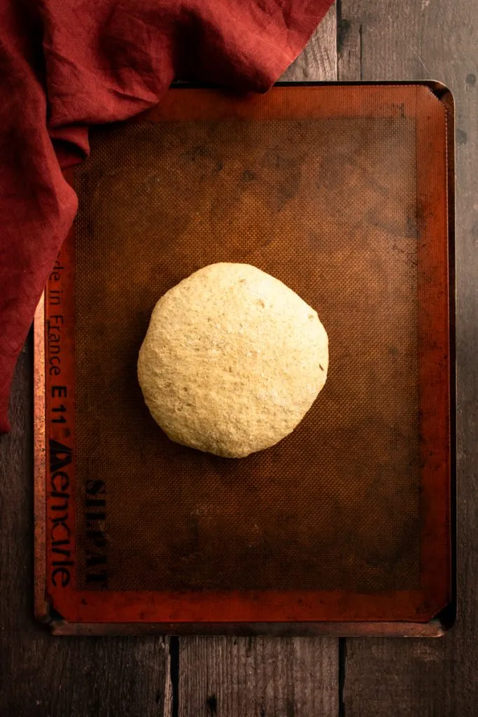 Roggenbrotteig, zu einem Kreis geformt auf einem Backblech.