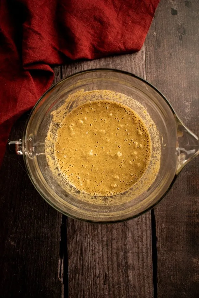 Roggenmehl und nasse Zutaten in einer Glasrührschüssel.