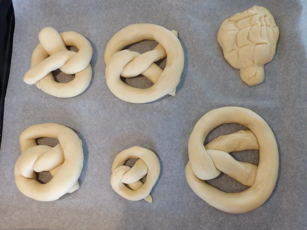 Rohe Laugengebäcke auf Backpapier vor dem Laugebad