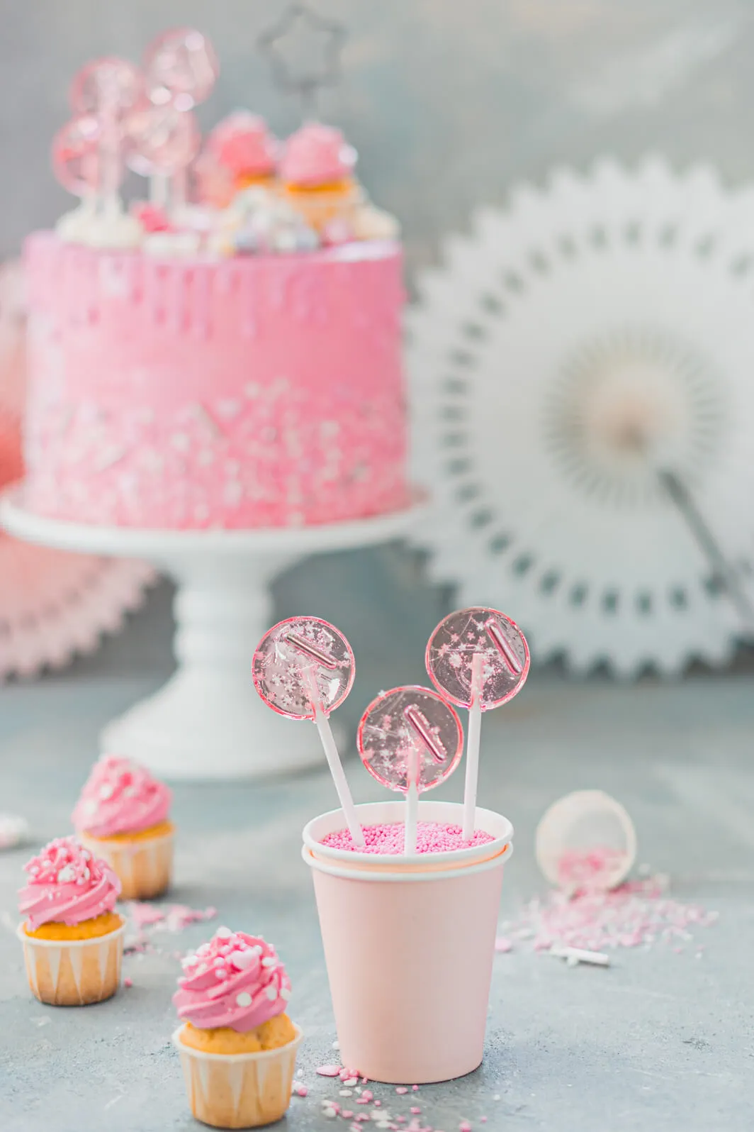 Rosa Drip Cake mit Lollies und Streuseln