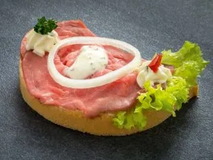 Rosa gebratenes Roastbeef auf einem Brötchen mit Garnitur