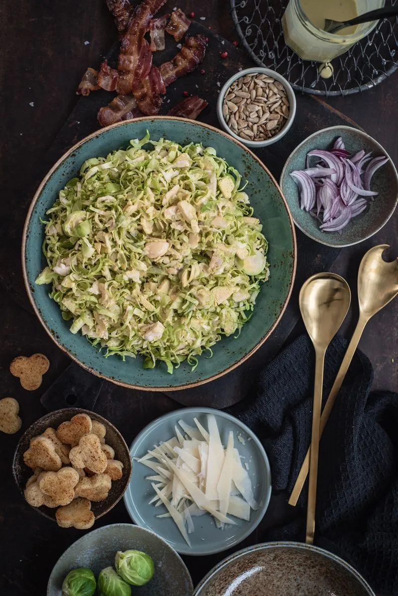 Rosenkohl Caesar Salad mit Parmesan, knusprigem Bacon und Croutons in einer eleganten Schüssel