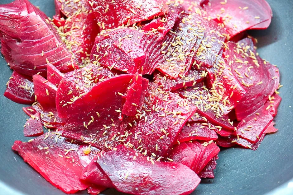 Rote Rüben Scheiben in einer Schüssel, gewürzt mit Kümmel, Essig und Öl für den klassischen Salat