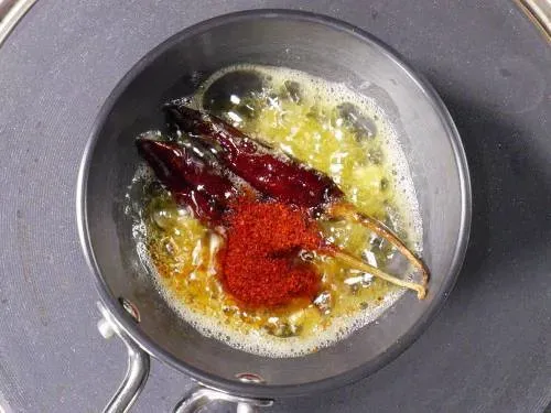 Rotes Chilipulver ins Tadka geben kurz vor dem Servieren