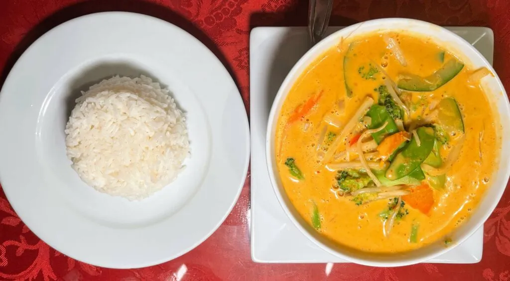 Rotes Curry mit verschiedenen Gemüsesorten und Reis, serviert im Saigon Sushi in Vero Beach